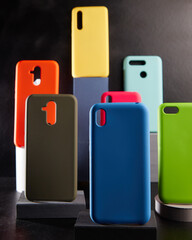 colorful cases for modern smartphones stand on stands on the table side view blurred background