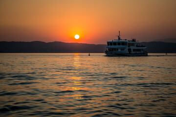 Passenger ship on the background of the sunset on Lake Garda. Lombardy, Italy