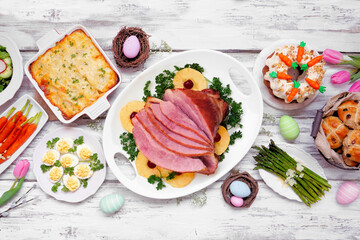 Classic Easter ham dinner. Top down view table scene on a white wood background. Ham, scalloped...