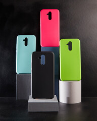 colorful cases for modern smartphones stand on stands on the table side view blurred background