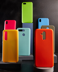 colorful cases for modern smartphones stand on stands on the table side view blurred background