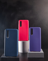 colorful cases for modern smartphones stand on stands on the table side view blurred background