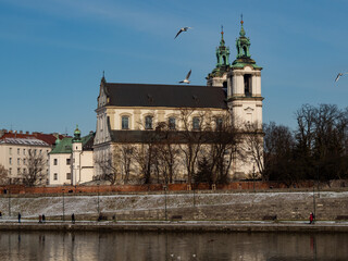 Fototapeta premium Poland, Cracow - view over Vistula Riverbanks and St. Michael the Archangel and St. Stanisław Church. Winter time.
