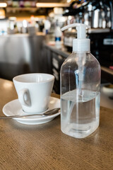 Fototapeta na wymiar Cup of espresso coffee on a bar counter and hydroalcoholic gel. Safety and hygiene concept