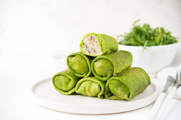 Homemade green vegetarian pancakes with filling ( potatoes and mushrooms), vegetable food, spinach pancakes on a white background