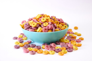 A closeup shot of multicolored fruity cereals in a blue bowl isolated on white background