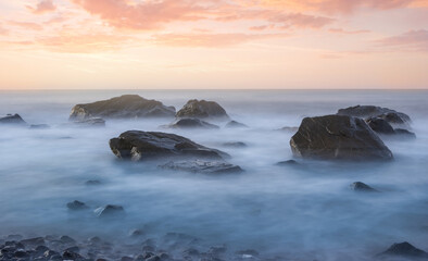 Fototapeta na wymiar quiet sea coast with stones at the twilight, natural sea background