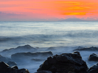 Obraz premium quiet sea coast with stones at the twilight, natural sea background