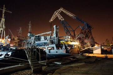 Fototapeta premium Cargo ship and cranes at night in port of Sevastopol, Crimea