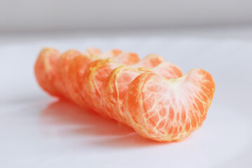 macro photo mandarin slices in a white plate close up several pieces of lie on the table background out of focus