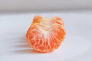 macro photo mandarin slices in a white plate close up several pieces of lie on the table background out of focus