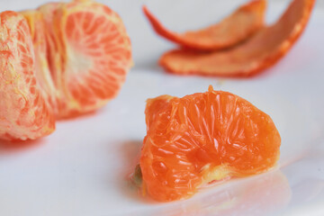 macro photo mandarin slices in a white plate close up several pieces of lie on the table background out of focus