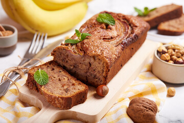 Fototapeta na wymiar Banana bread with walnuts, hazelnuts and cinnamon. Sweet homemade dessert. 