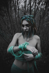 dead girl in autumn foliage wearing green and yellow robes