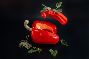flying red, sweet pepper on black background