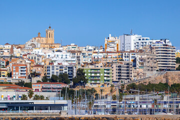 Fototapeta premium Spain; Jan 2021: Downtown views of the city of Tarragona, Cathedral church at the background, colorful apartment buildings, sailing club by the port. Tarragona by Mediterranean sea, Catalonia, Spain
