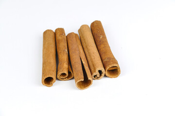cinnamon sticks in the foreground, white background, spices, isolated