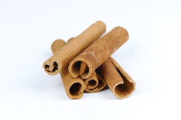cinnamon sticks in the foreground, white background, spices, isolated