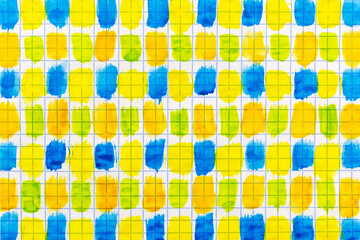 Strokes of watercolor paint of blue, green, orange and yellow colors on a sheet of paper in a cell...