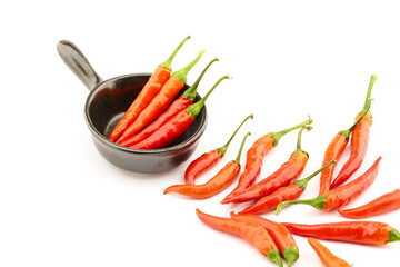 composition of hot peppers in a black bowl glass bowl on a white background