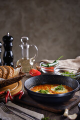 Turkish Scrambled Eggs with Tomatoes and Peppers in a frying pan on wooden table close-up