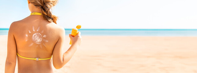 Child girl smears sun cream on her face. Selective focus.