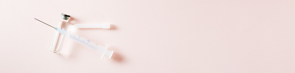 Vaccination and Immunization. Opened syringe on a glass vial with vaccine. Top view. Web banner