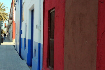 Colorful facades of barrio buildings with a rear view of a walking person, Valencia, Spain