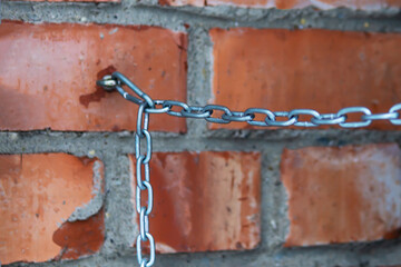 the blurred chain is connected to a brick wal