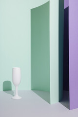 Pastel green and violet purple background with the champagne flute and sharp shadows. Minimal aesthetic concept.