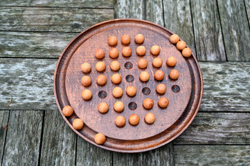 Top view of a solitaire ball game on a wooden table
