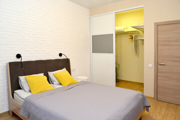 Bedroom with double bed and dressing room in a niche. Ecominimalism