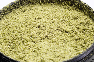weed grinder full of hemp trichomes of dry medical marijuana flower buds macro image