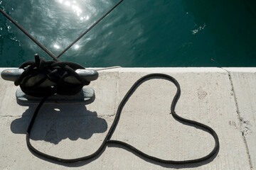 Heart shaped mooring rope on sea pier