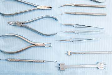 Dental tools and artificial jaw model for the orthodontic treatment lying on the table at the dental office, close-up. High quality photo