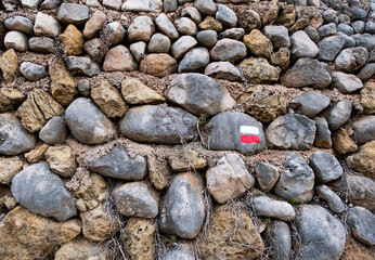 Signs GR painted on a stone wall to help hikers navigate the mountain.