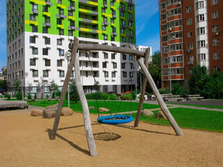 Fototapeta na wymiar Swing on the playground in the urban courtyard