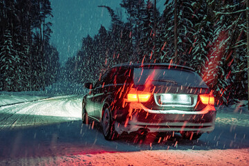 Car Driving on Night Road in Winter Forest