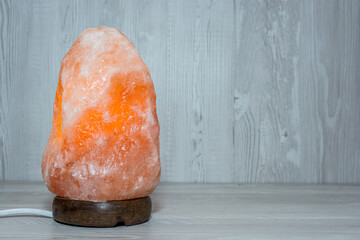 Himalayan salt lamp on wooden background