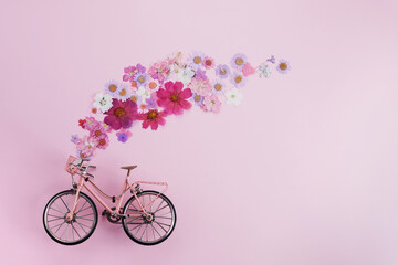 Flowers fly out from pink bicycle bascet on pink background. Romanitic concept for Valentine day,...