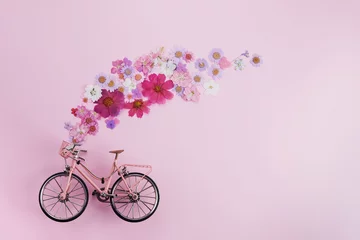 Deurstickers Bloemen vliegen uit roze fietsbascet op roze achtergrond. Romantisch concept voor Valentijnsdag, vrouwen of moederdag. © vetre
