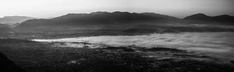 Black and white view of Terni covered by the fog in a winter sunrise, Umbria, Italy