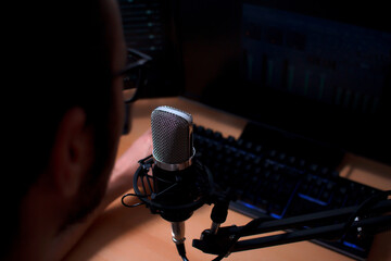 Local radio announcer in his studio with microphone on the main stage. Audiovisual communication