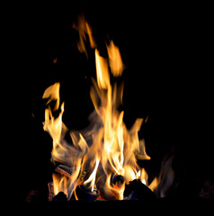 firewood in the grill burns with a bright flame against the background of a dark night