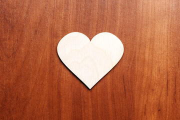 wooden heart symbol on wooden background. valentine greeting card concept. above view