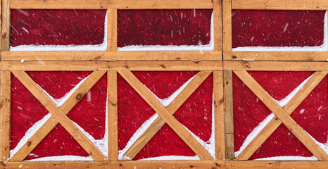 wooden wall in German or Scandinavian style covered snow in winter - the yellow wooden planks is on...