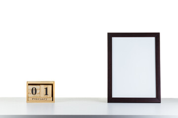 Wooden calendar 01 february with frame for photo on white table and background