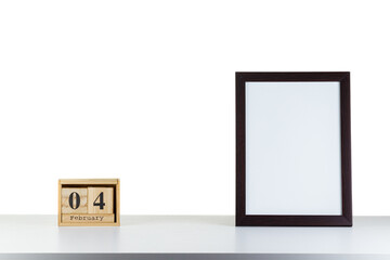 Wooden calendar 04 february with frame for photo on white table and background