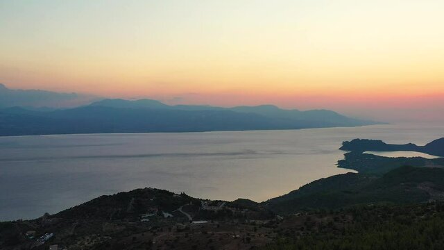 
Drone footage of a beautiful sunset at the Gerania mountain in Greece. The drone is facing the sea where the sun is setting, then pan to the right, to see the side of Gerania mountain. 1080p