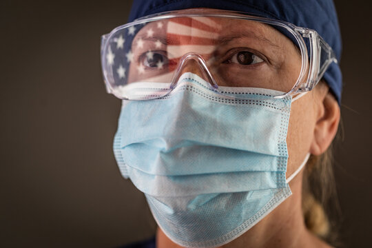 American Flag Reflecting on Female Medical Worker Wearing Protective Face Mask and Goggles - Powered by Adobe